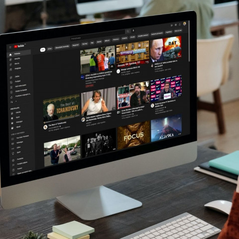 Kako uključiti dark mode na Youtubu Osoba sjedi ispred računala na kojem je otvoren Yooutub sa tamnim načinom rada