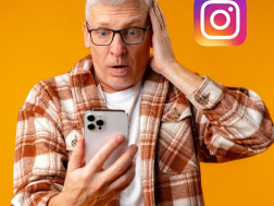 Stariji muškarac drži mobitel u jednoj ruci dok se drugom drži za glavu u panici zato što je izbrisao poruke na Instagramu