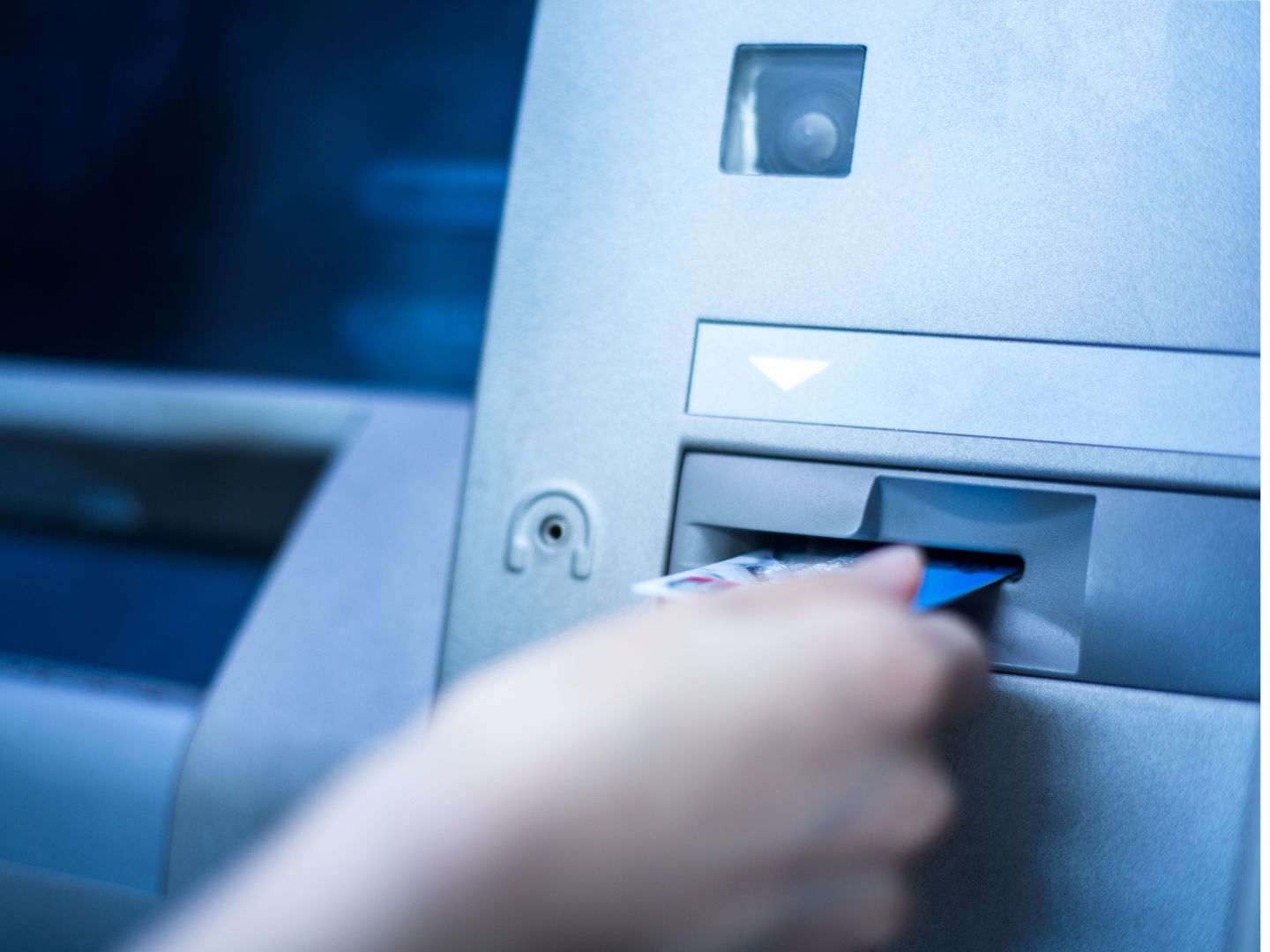 Ženska ruka ubacuje karticu u bankomat na kojem će uplatiti novac