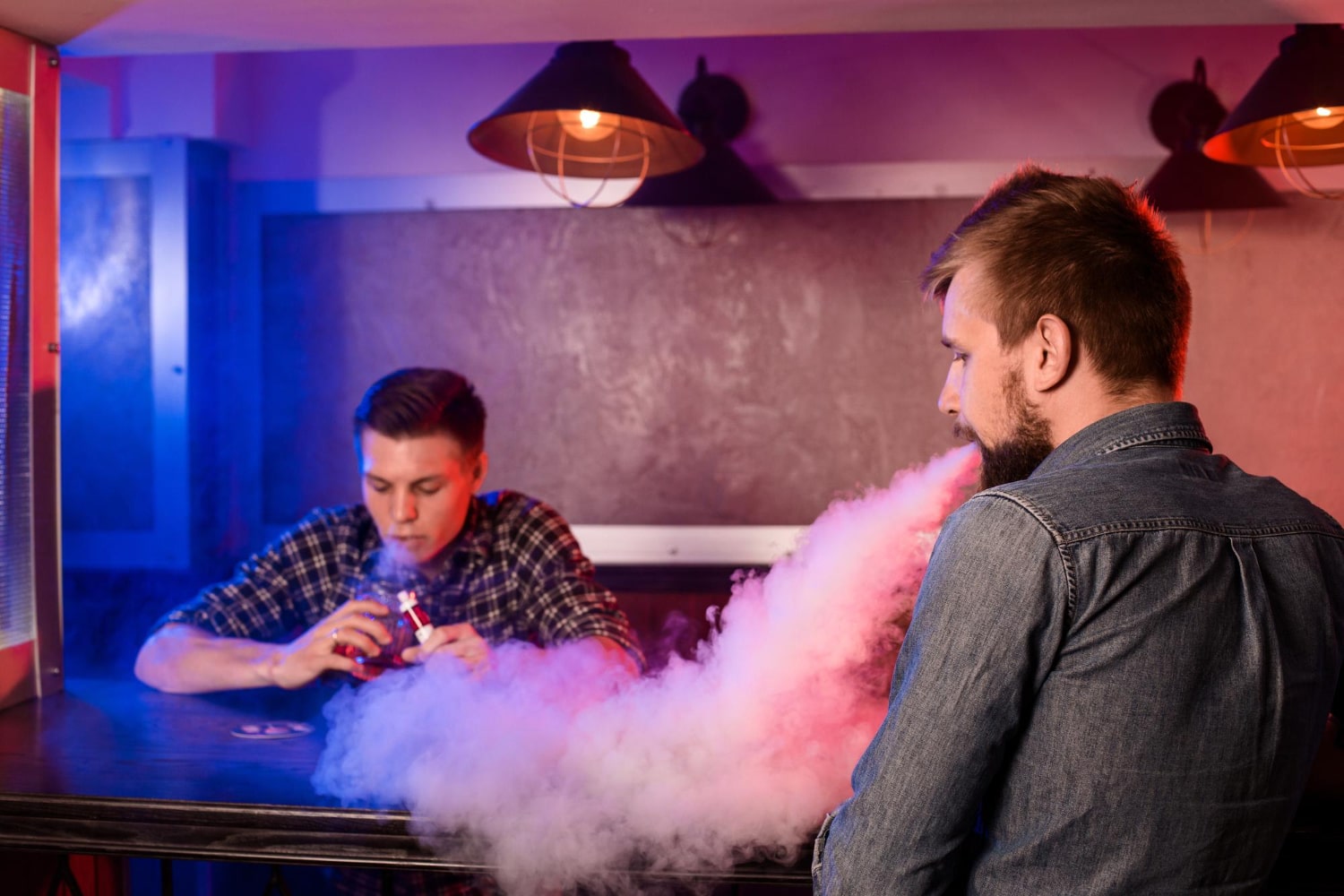 dva muškarca puše e cigaretu