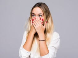 Kako zaustaviti štucanje Žena prikriva usta rukama kako se ne bi primijetilo da štuca