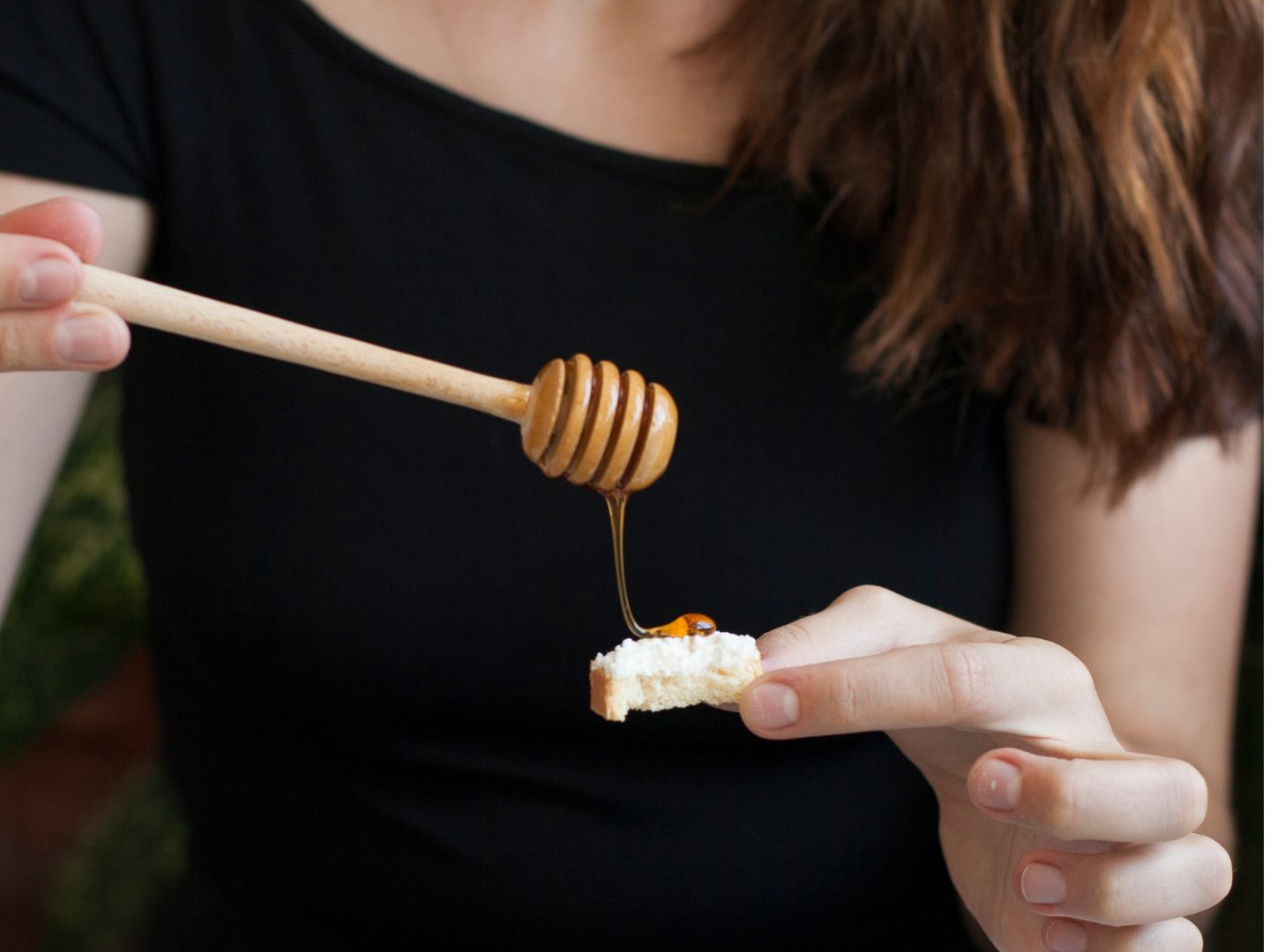 Probaj med Žena nanosi med na kruh kako bi testirala kvalitetu meda