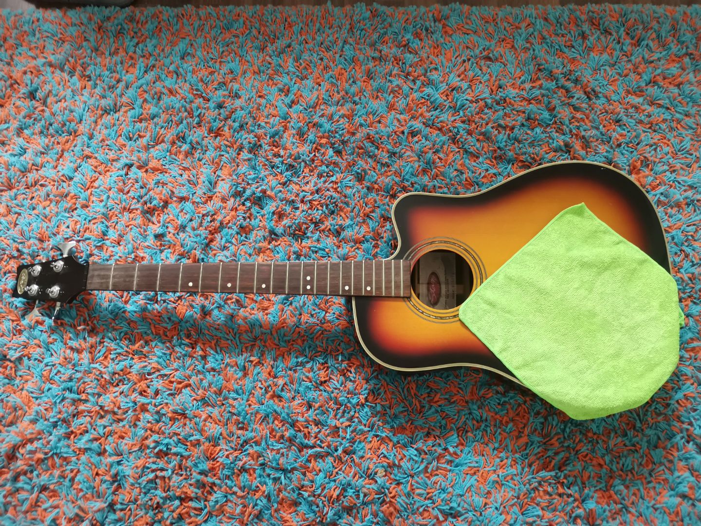 Čišćenje vrata akustične bas gitare Akustična bas gitara bez žica i zelena krpa