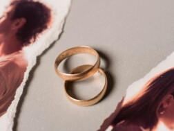 Vjenčani prsteni između prelomljene slike bračnog para koji je u procesu razvoda i koji se sprema napisati zahtjev za razvod