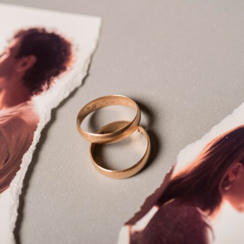 Vjenčani prsteni između prelomljene slike bračnog para koji je u procesu razvoda i koji se sprema napisati zahtjev za razvod