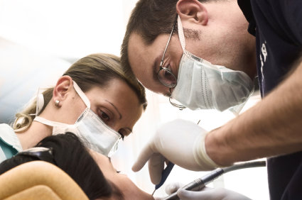 Tandläkare genomför en rotfyllning på en patient.