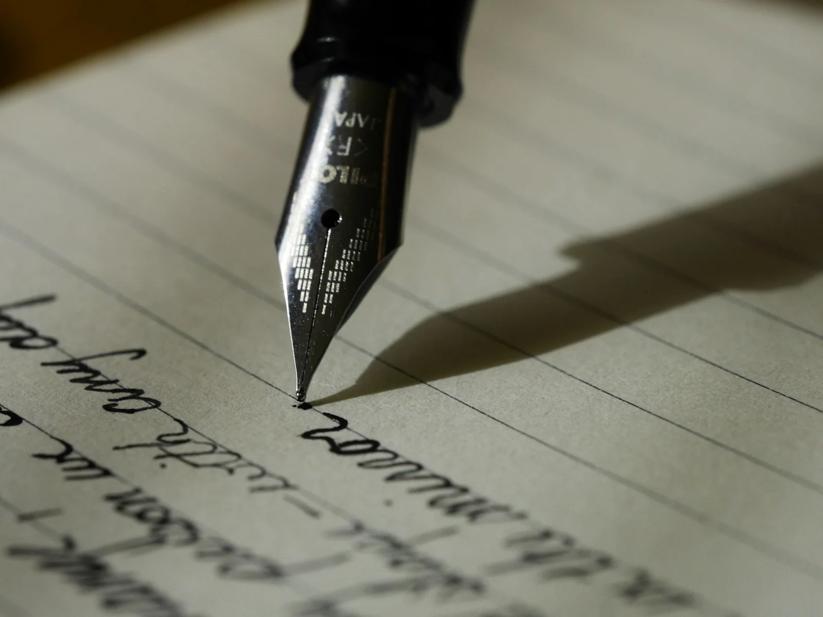 Linen-bound notebook on a desk with a pen and pressed flower