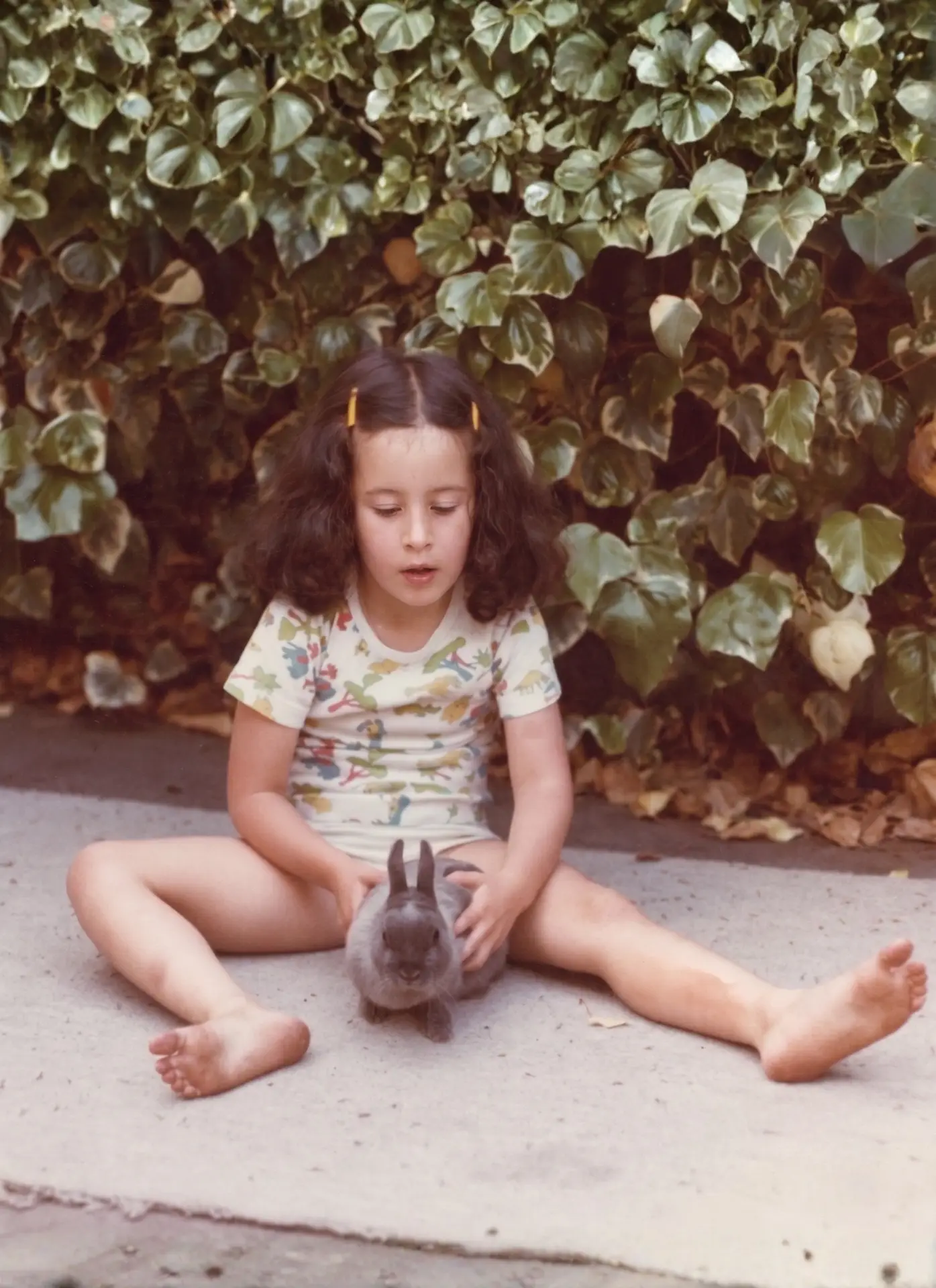 Tashi as a young child sitting with a rabbit