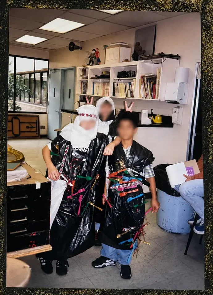 Students wearing their recycled-material art creations