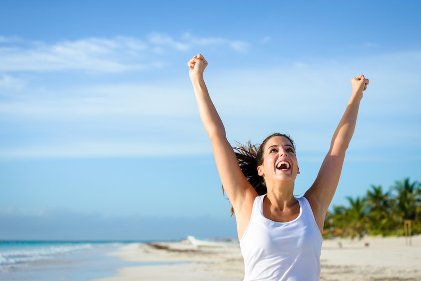 An image of sporty woman running and raising arms to illustrate women’s health success stories