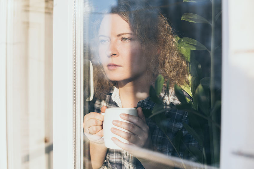 An image of woman on the window to illustrate the Health Side Effects Of The Pandemic & Lockdown