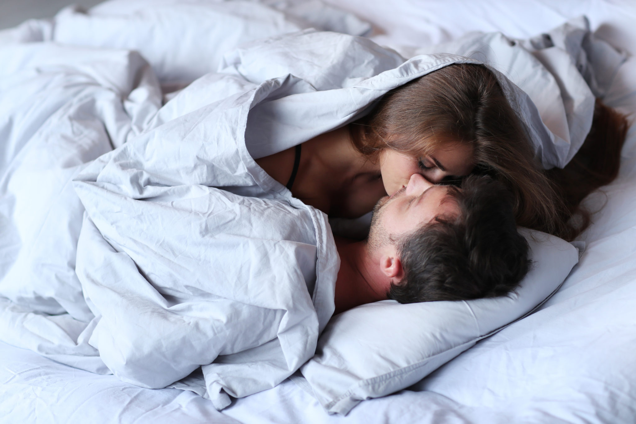 Парень и девушка целуются в постели фото