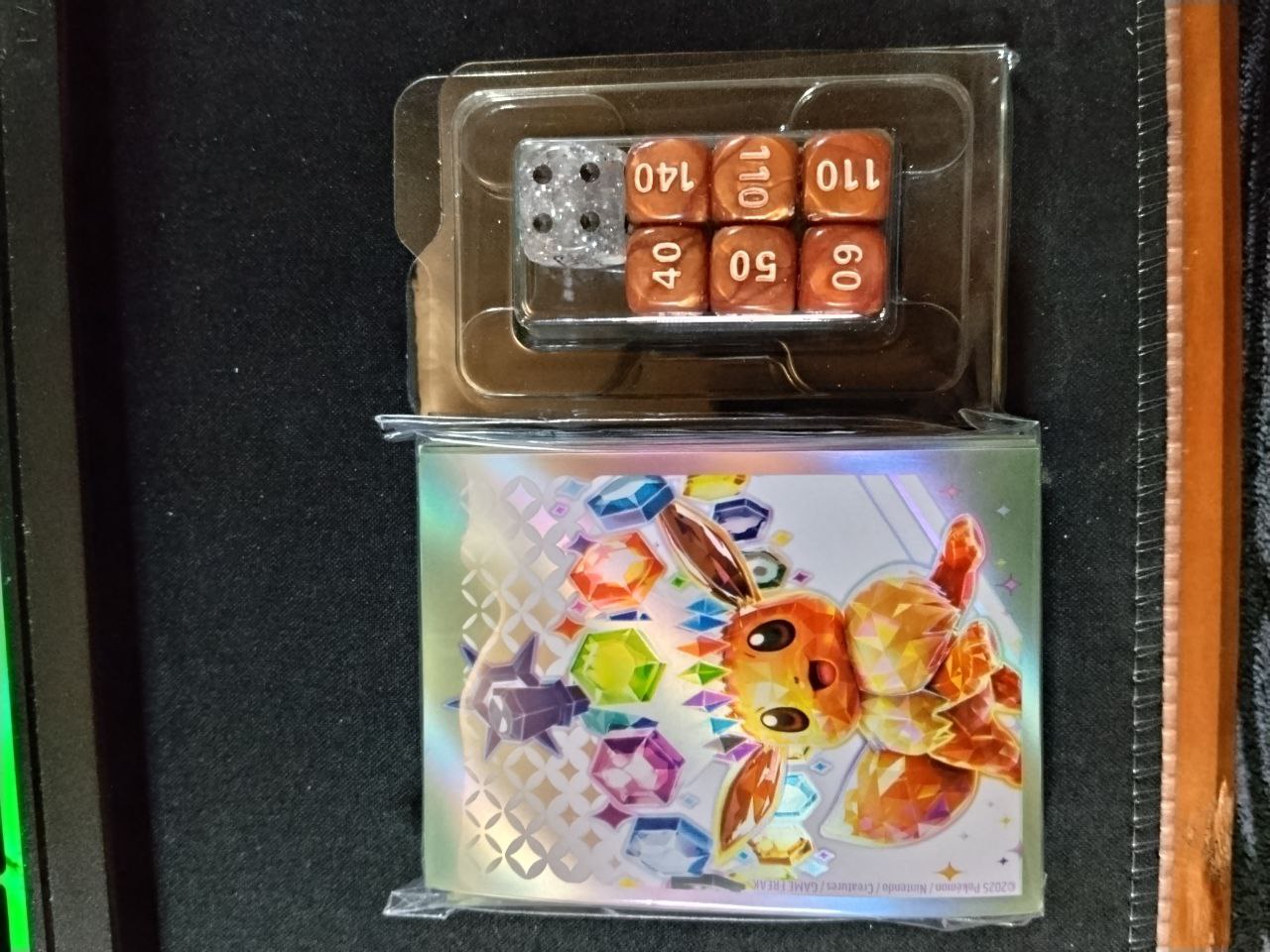 Protectores Eevee Prismatic Evolutions sellados sin uso con sus dados