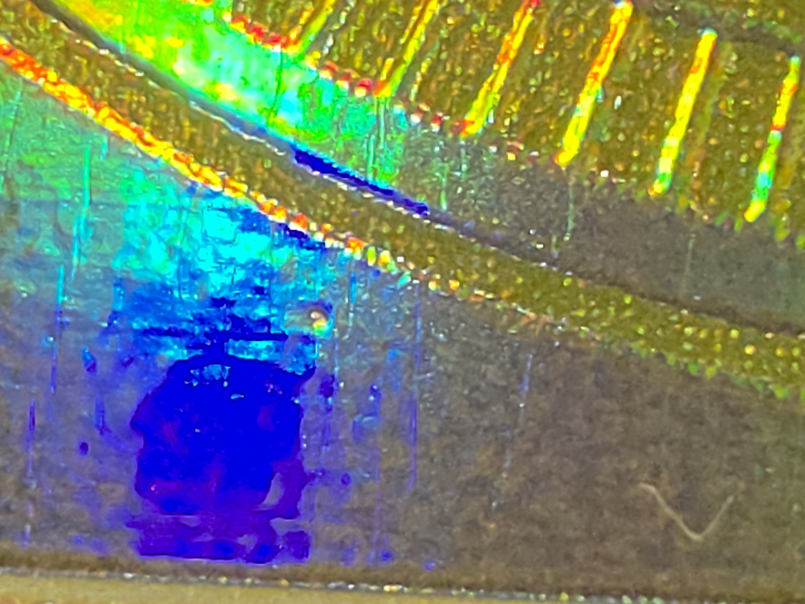 Front defect macro, blue and green through the holo.