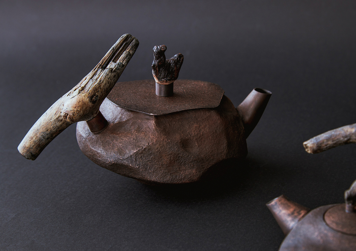 The body of the second teapot features a sharper stone-like texture, accentuating its irregular raised and depressed patterns.