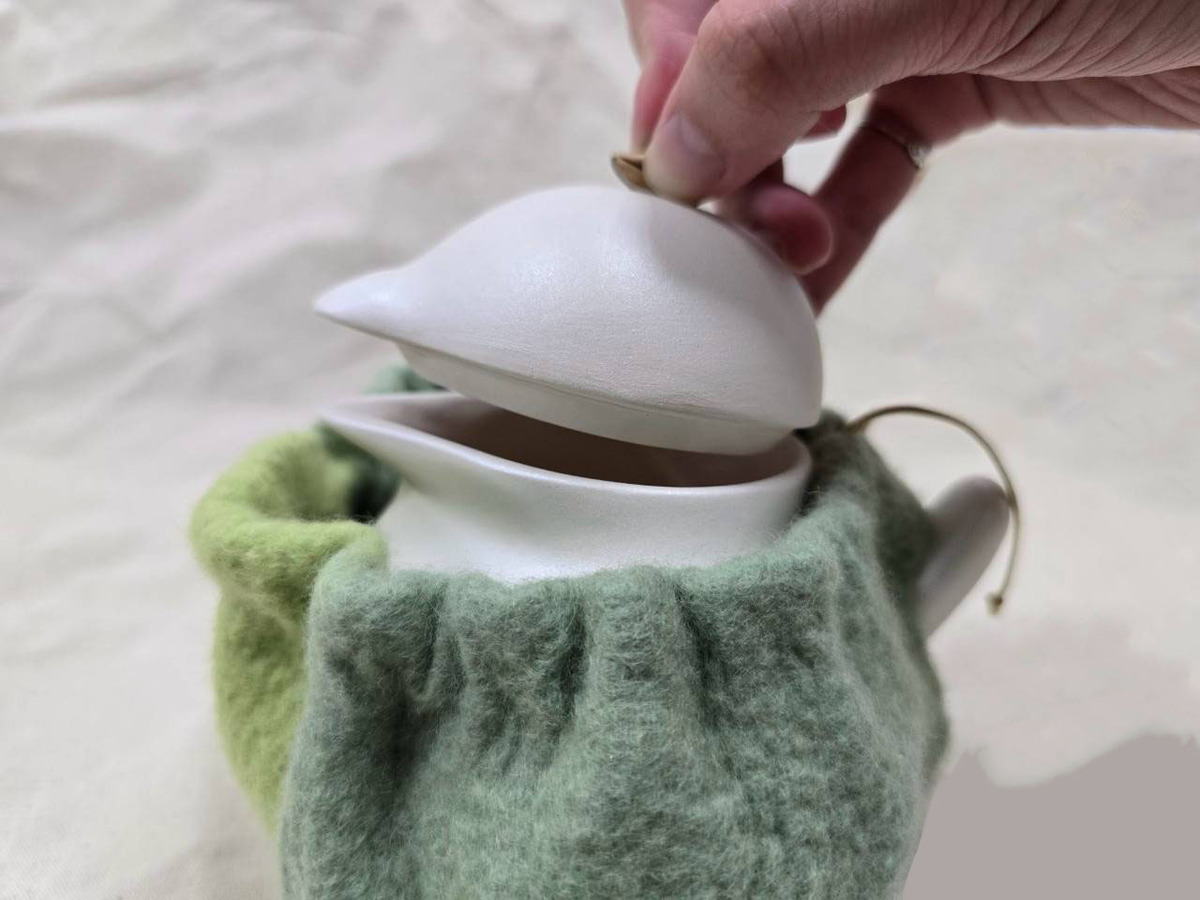 可經由捏茶扭的方式打開，茶壺下半身用來裝茶水進去和倒茶的動作