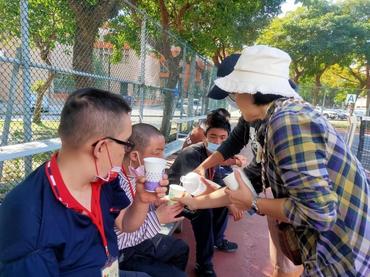 機構學員在公園郊遊休息共享飲水歡樂時光中