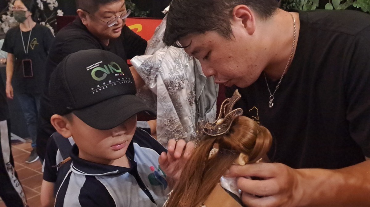 三昧堂人員指導小朋友如何操作戲偶