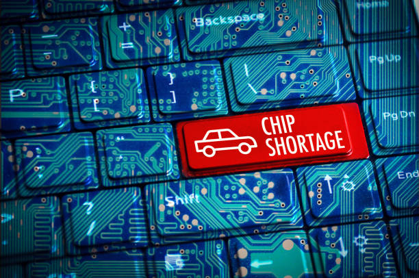 Chip Shortage or semiconductor automotive crisis concept with computer keyboard and motherboard circuits