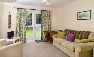 The bungalow's living area has double doors out into the garden