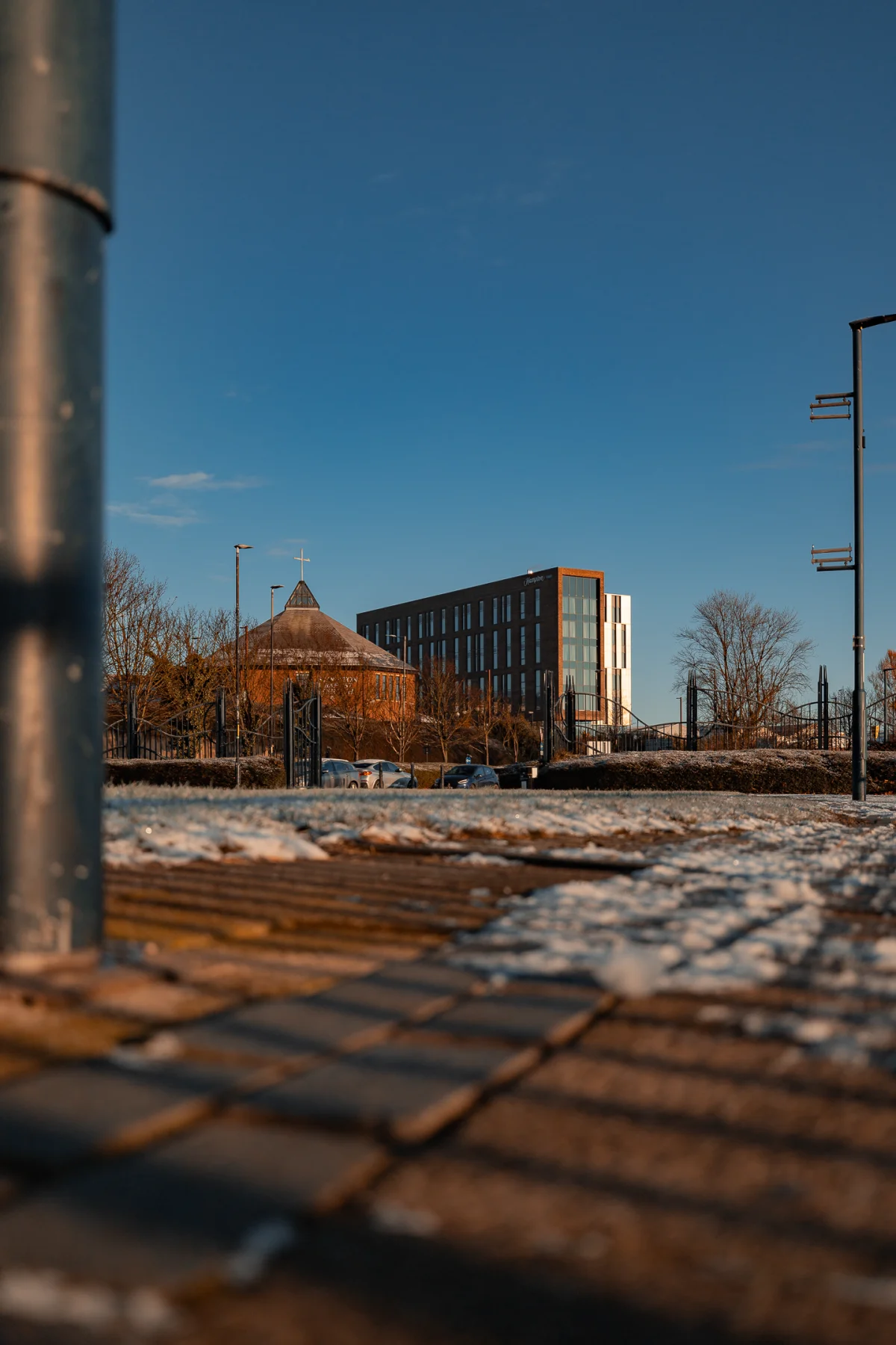 Modern city architecture featuring a church and office building under a clear blue winter sky.