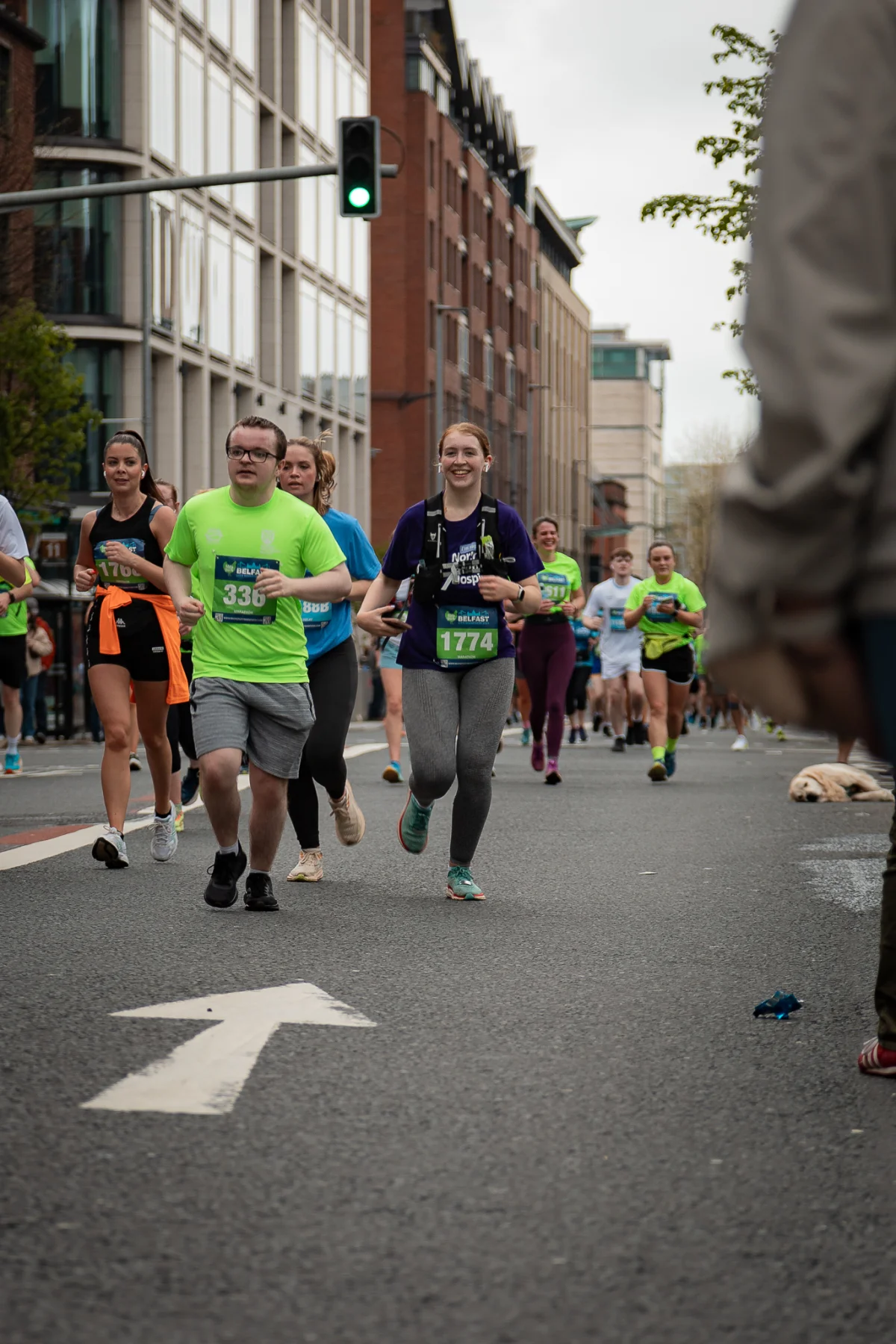 A group of diverse runners participating in an urban marathon on a city street.