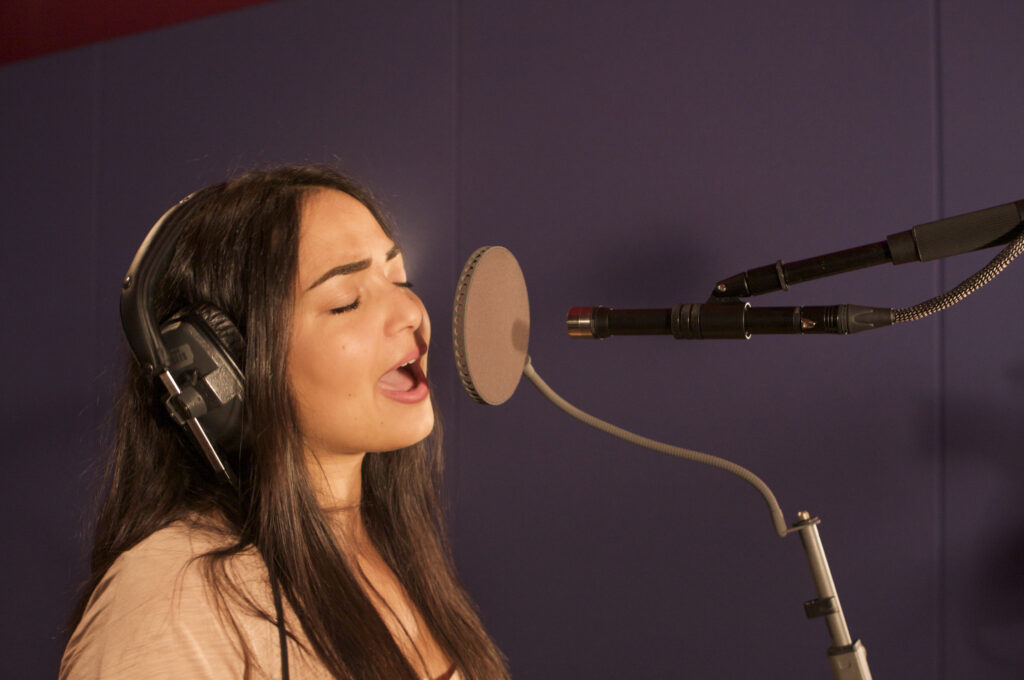 Sängerin Bahar Kizil mit geschlossenem Kopfhörer im Studio