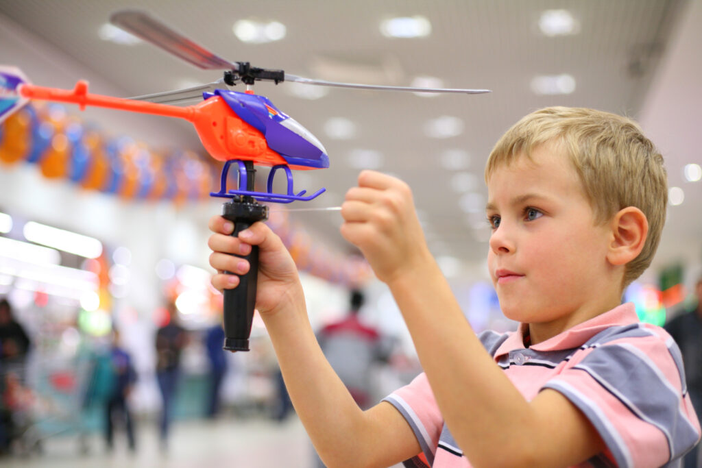 Boy in shop with toy helicopter