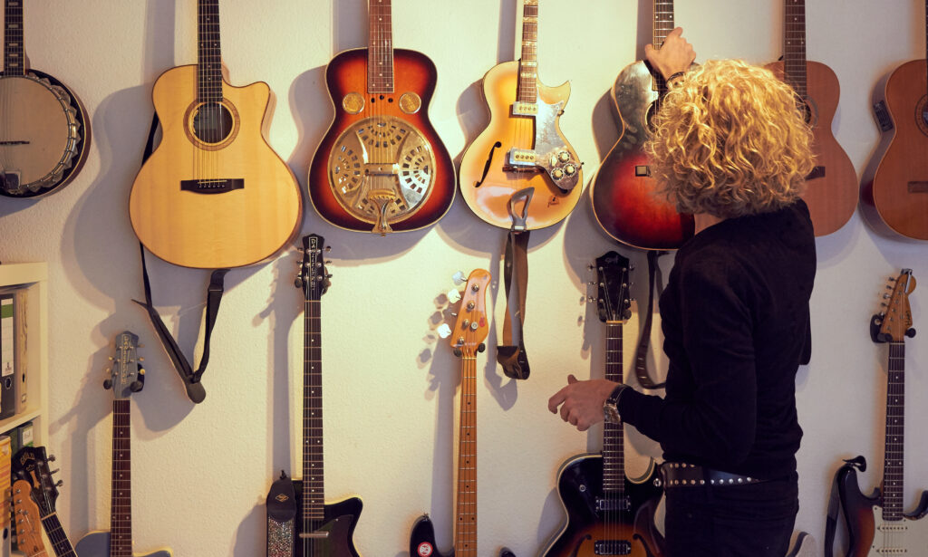 Andreas vor seiner Gitarrenwand: "Alle werden gespielt, ich bin kein Sammler.", betont er während der Fotosession. Bild © Christoph Behm