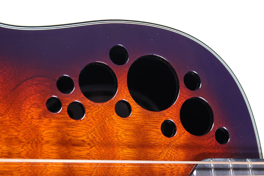 Die Ovation Elite Plus 8-String besitzt die bekannten kleinen Schalllöcher, aber ohne die sonst üblichen Epauletten.