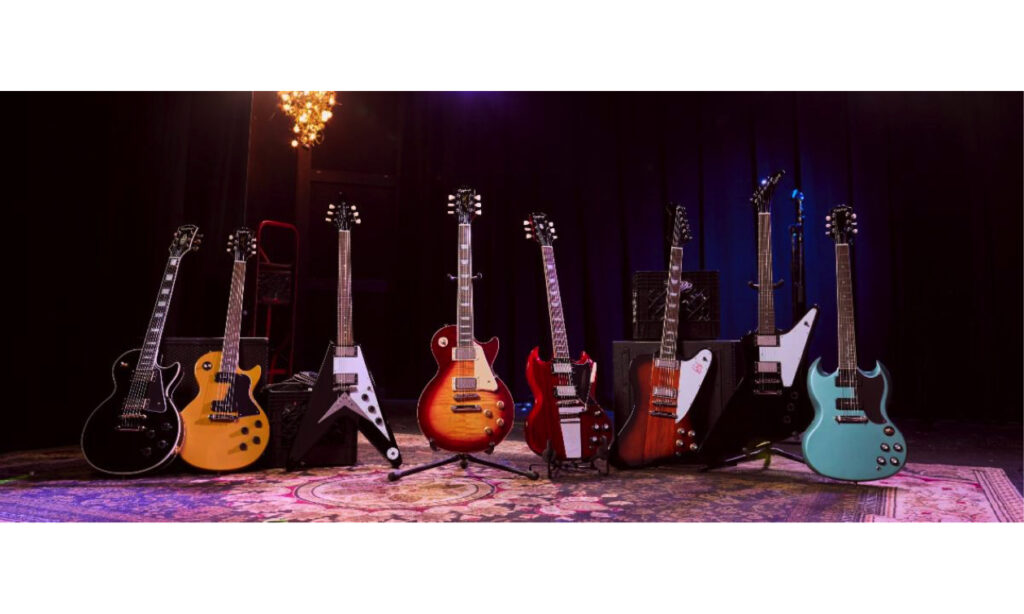 Epiphone Inspired by Gibson Collection L-R: Les Paul Custom in Ebony, Les Paul Special in TV Yellow, Flying V in Ebony, Les Paul Standard 50s Heritage in Cherry Sunburst, SG 61 Maestro in Cherry, Firebird in Vintage Sunburst, Explorer in Ebony and SG Special in Pelham Blue.