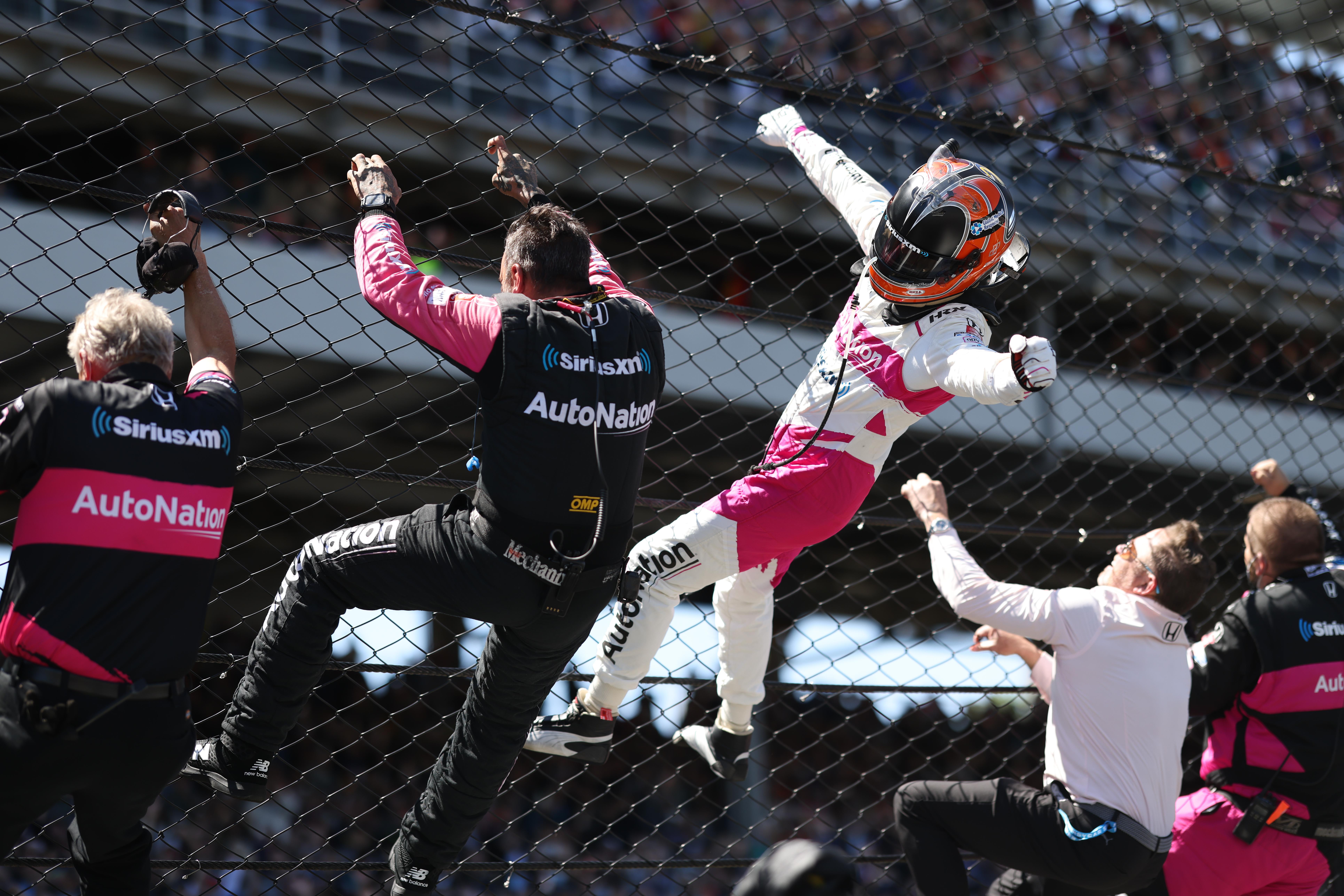 Helio Castroneves Climbs The Front Stretch Fence After Winning The 2021 Indianapolis 500 Largeimagewithoutwatermark M50392