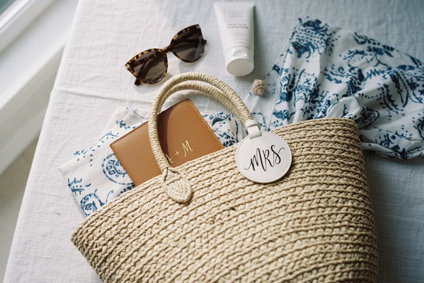 Honeymoon gift ideas for the bride laid out on linen