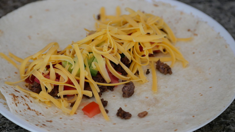 A picutre of a soft shelled taco rolled on a plate.