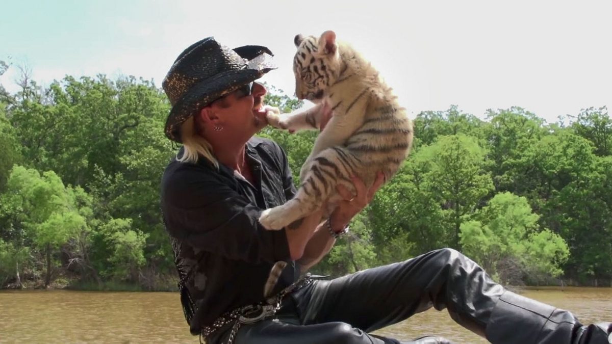 A country music video featuring a man holding a tiger cub.