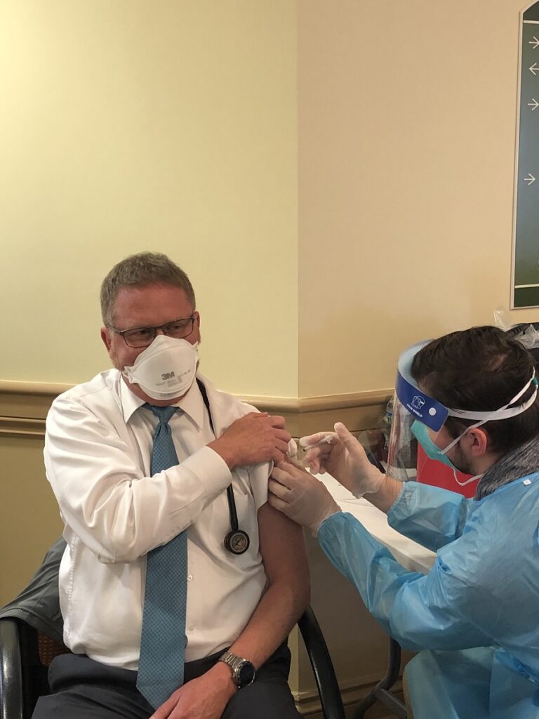 Medical team member gives The Glebe team member vaccine for Covid19