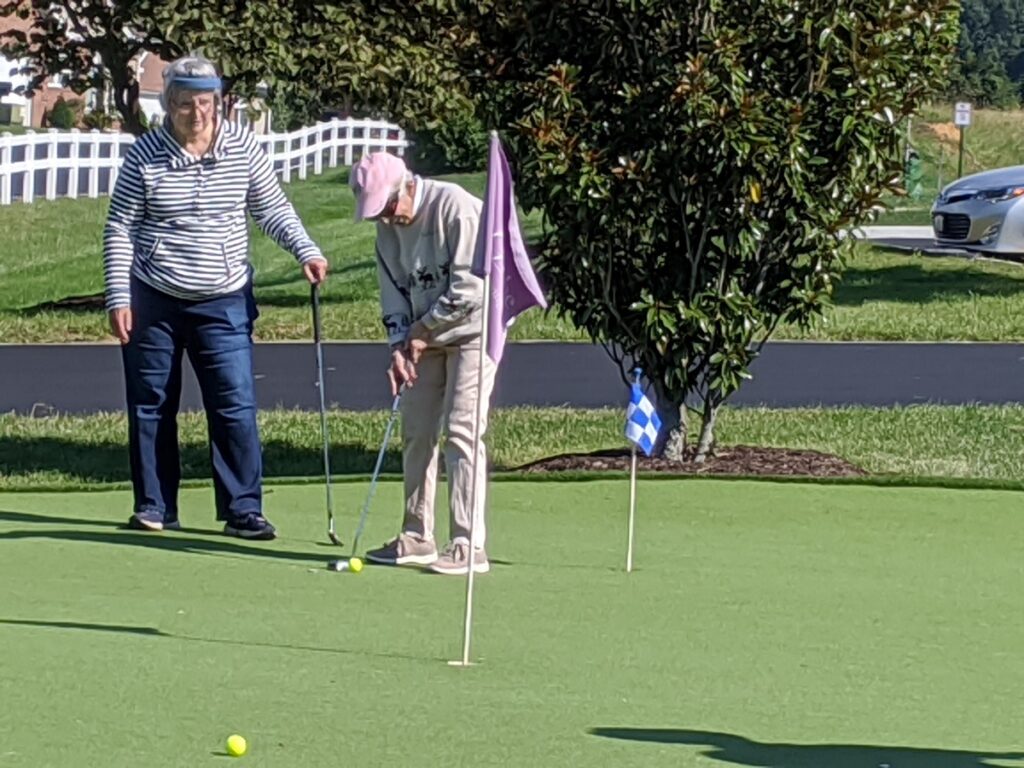 Senior residents playing putt putt golf.