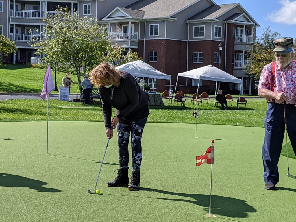 A senior resident playing putt putt golf.