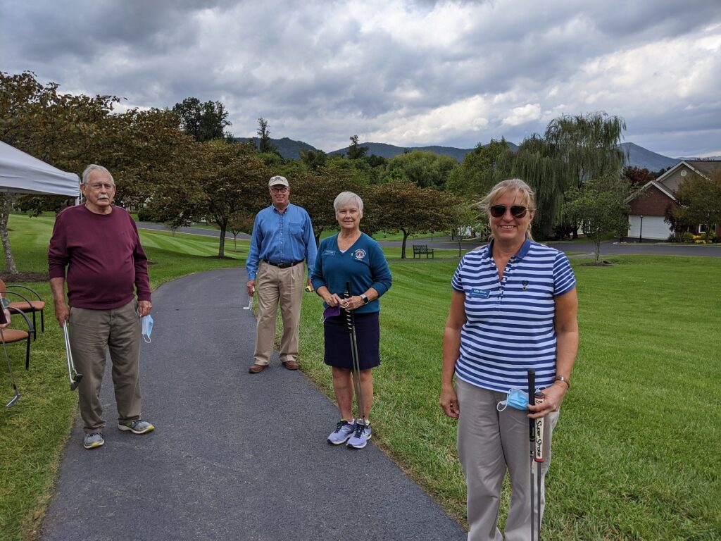 Residents playing golf pause to pose for a picture.