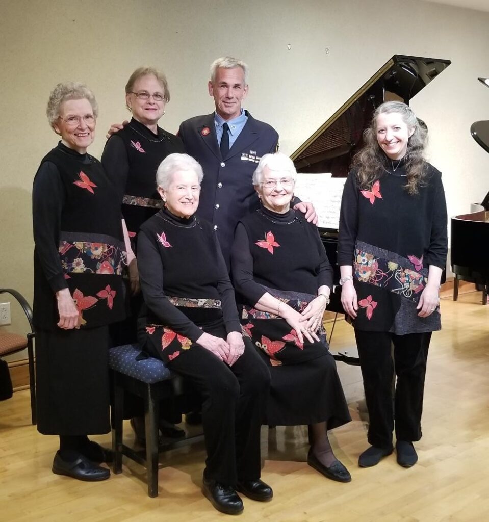 Carole Edwards and friends posing with piano