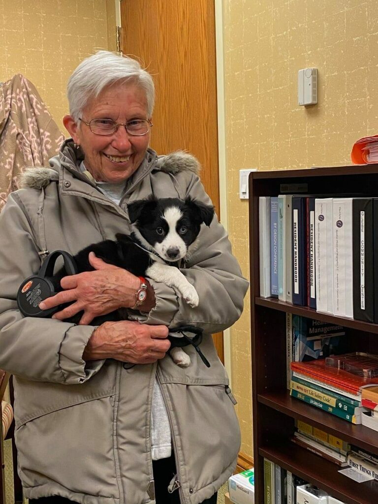 Senior resident poses with puppy