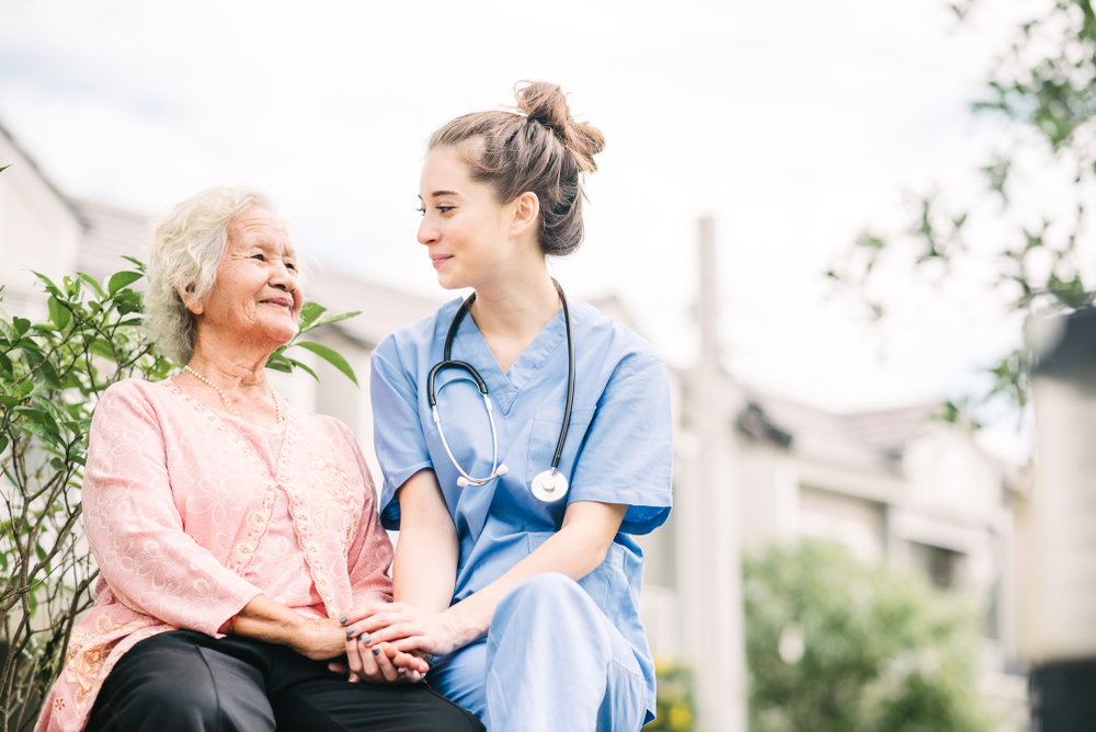 Assisted living resident sitting with a nurse