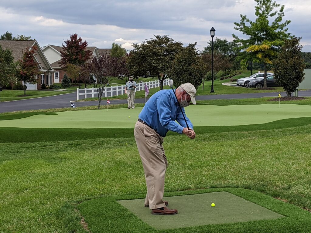 A senior resident playing golf.