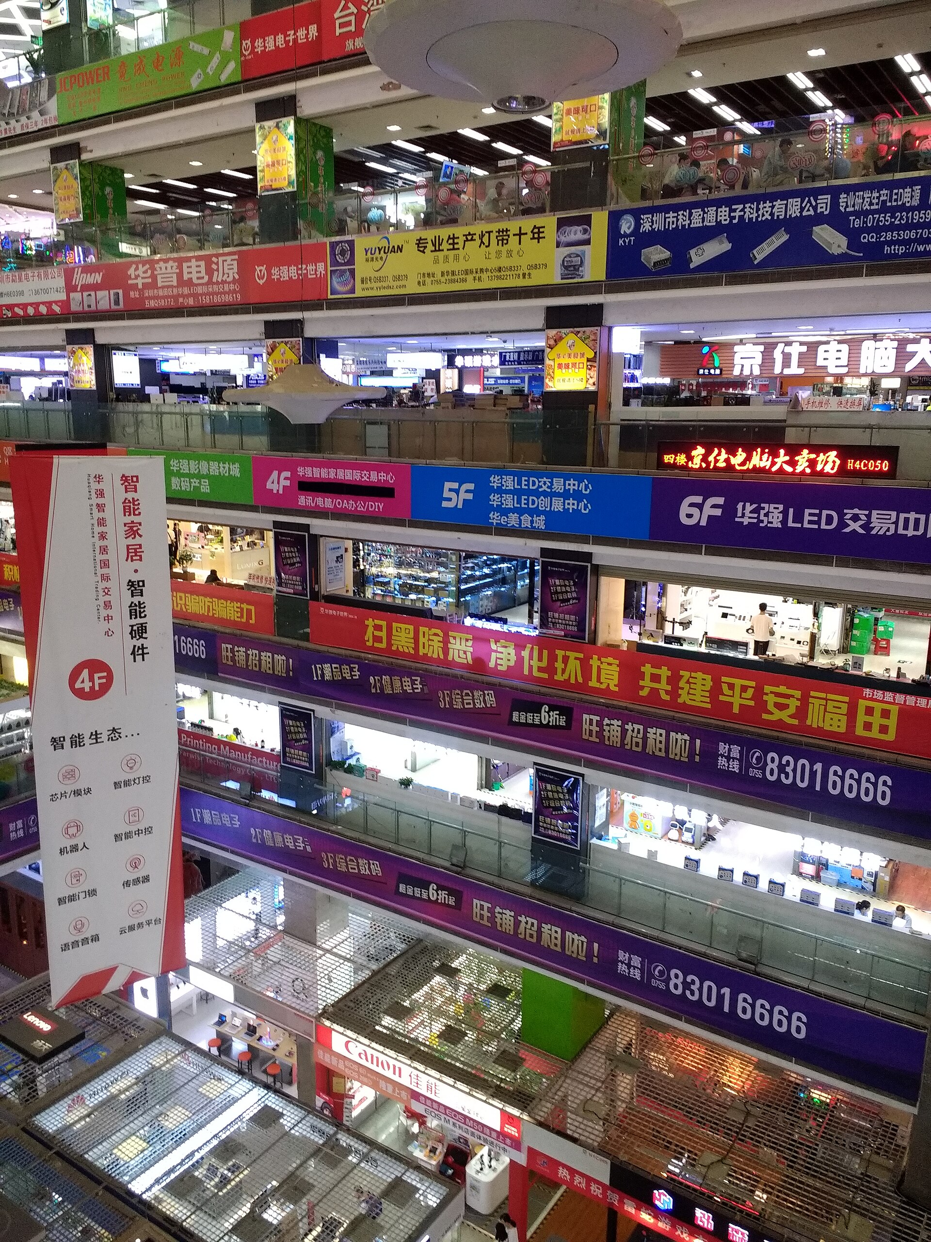 Interior of Huaqiang Electronics World in Shenzhen, with floor after floor of small component stalls and signage in Chinese.