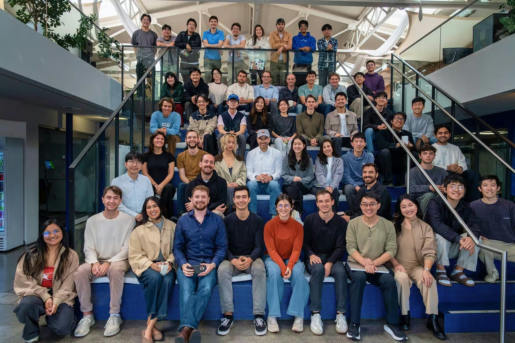 Several dozen Exa employees posed on a blue staircase and balcony inside the company's office