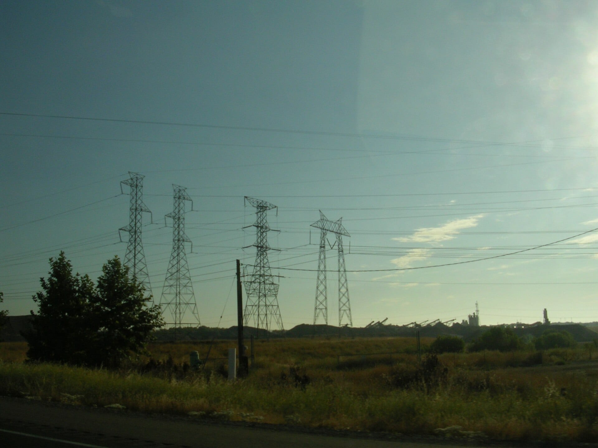 PG&E transmission towers and high-voltage lines above dry grassland along Interstate 505 in California