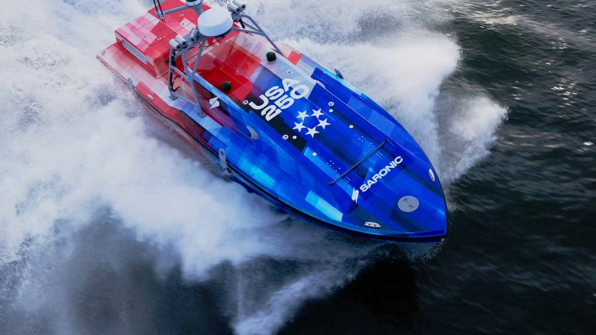 A Saronic Corsair autonomous surface vessel, painted in a red, white and blue USA 250 camouflage livery, cuts through open water