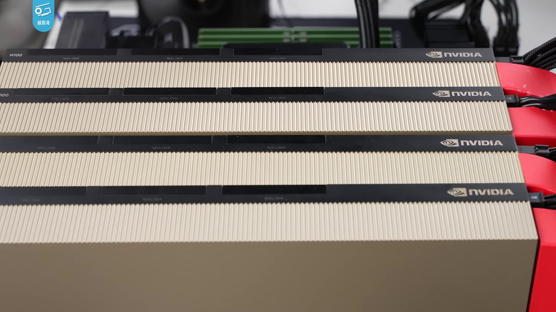 Four Nvidia H100 data-center GPUs stacked in a server chassis, gold heatsinks and Nvidia logos visible.
