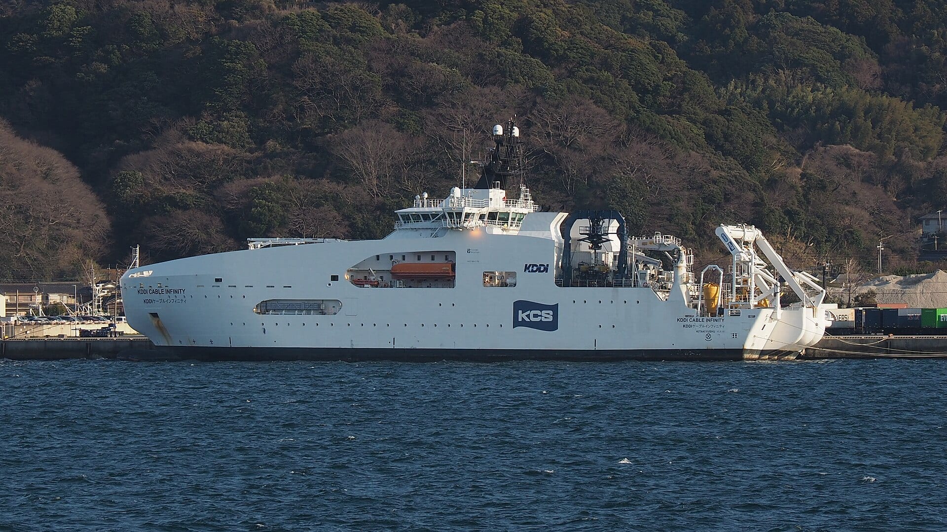 O navio de cablos KDDI Cable Infinity atracado em Kitakyushu, no Japão, com o equipamento de manuseio de cabos visível na popa