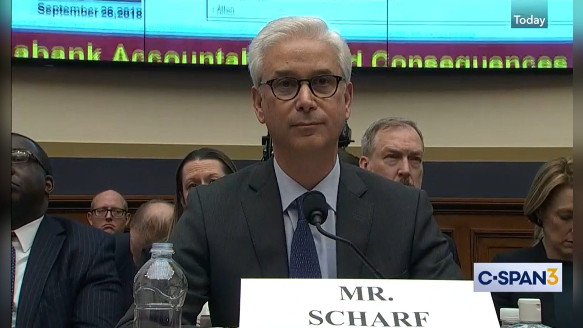 Wells Fargo chief executive Charles Scharf testifying before the House Financial Services Committee, seated at a microphone behind a nameplate reading Mr. Scharf.
